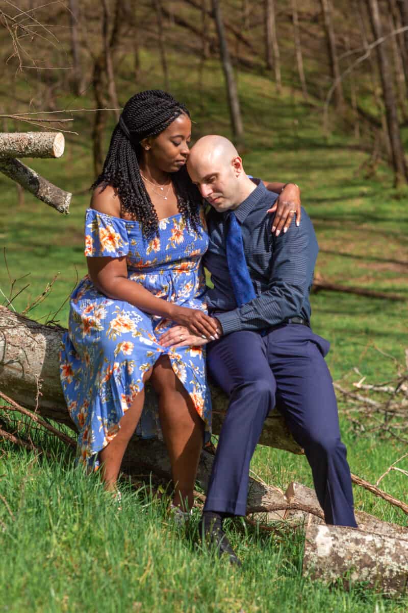 Spring Nashville Elopement at Butterfly Hollow; bride and groom embrace as they sit on a fallen tree trunk